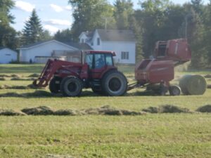 Harvesting machinery at Deering Farms LLC efficiently collecting crops in a sustainable agricultural field.